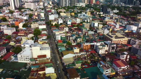 Aerial-flying-over-the-colorful-streets-of-Makati-city,-golden-hour-in-Philippines