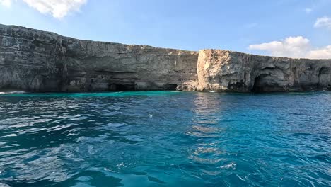 The-boat-ride-from-Malta's-harbor-to-the-Smugglers-Cave-Reef,-a-shallow-reef-nestled-in-a-cove-at-the-base-of-cliffs