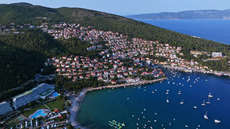 Aerial-view-of-a-coastline-full-of-holiday-homes,-sunny-evening-in-Rabac,-Croatia