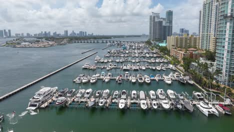 Hiperlapso-Aéreo-Del-Puerto-Deportivo-De-Miami-Beach-Que-Muestra-Yates-De-Lujo-E-Impresionantes-Vistas-Al-Mar-Con-El-Horizonte-De-La-Ciudad-Y-La-Calzada-Macarthur-Al-Fondo