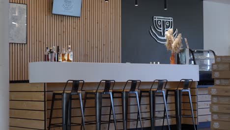 Slow-establishing-shot-of-chairs-sat-at-a-counter-within-a-winery-store