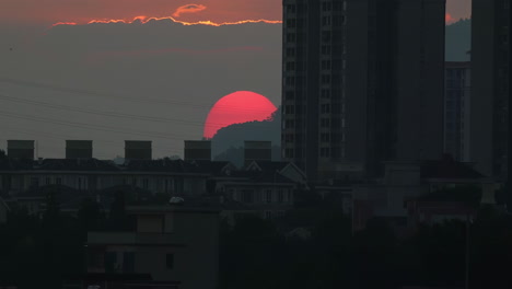 Naturfarbenprächtige-Skyline-Der-Stadt-Unter-Dem-Wunderschönen-Sonnenuntergang-Mit-Bewegten-Wolken,-Atemberaubender-Sonnenuntergang-Wirft-Einen-Warmen-Schein-über-Eine-Große-Stadt-Und-Präsentiert-Hoch-Aufragende-Gebäude