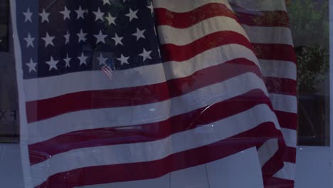 American-flags-flying-in-the-wind-in-front-of-stores-in-downtown-Fredericksburg,-Virginia-with-gimbal-video-in-slow-motion