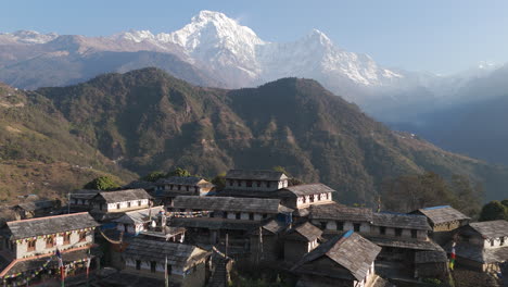 Vista-Aérea-Por-Drones-De-Casas-Tradicionales-Nepalíes-En-La-Aldea-De-Ghandruk,-Kaski,-Nepal,-Con-La-Cordillera-De-Annapurna-Y-Machhapuchhre-Al-Fondo