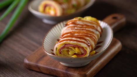 Pouring-thick-soy-sauce-over-Taiwanese-omelette,-egg-pancake-roll.