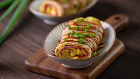 Pouring-thick-soy-sauce-over-Taiwanese-omelette,-egg-pancake-roll.