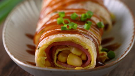 Pouring-thick-soy-sauce-over-Taiwanese-omelette,-egg-pancake-roll.