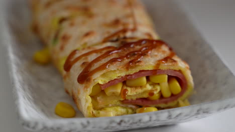 Pouring-thick-soy-sauce-over-Taiwanese-omelette,-egg-pancake-roll.