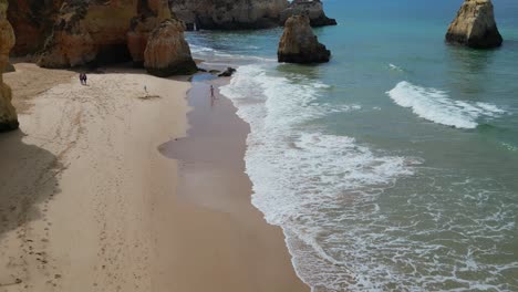 High-view-of-portuguese-beach-and-cliffs,-family-couple-and-kids-in-Cascais,-Portugal