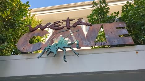 Close-up-of-Weta-Cave-sign-post-at-the-entrance-of-gift-shop-and-museum-in-Wellington,-New-Zealand-Aotearoa