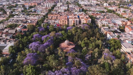 Hermoso-Kiosko-Santa-Maria-La-Ribera-Ajardinado-Con-árboles-Coloridos,-Ciudad-De-México,-Disparo-De-Drone