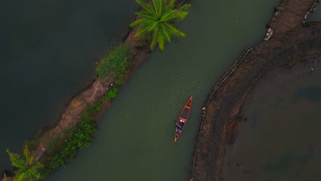 Un-Río-Lleno-De-Cocoteros-Y-Pasa-Un-Barco,-Río-Del-Bosque-De-Cocos,-Alleppey-Alappuzha