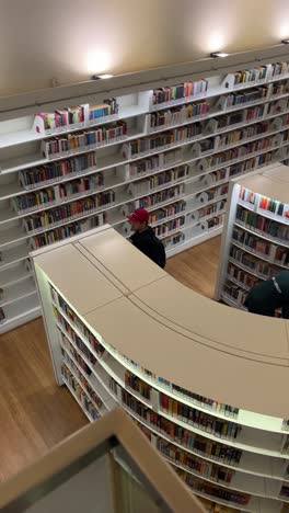 Top-View-Of-Man-Wearing-Casual-Outfit-Walking-Inside-The-Modern-Library