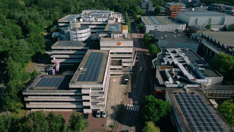 Drone-footage-captures-the-NPO-and-NOS-studio-and-office-building,-the-headquarters-of-Dutch-public-broadcaster,-showcasing-its-modern-architecture-and-bustling-media-activity