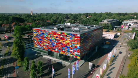 Drone-footage-orbits-the-colorful-Beeld-en-Geluid-museum,-a-landmark-dedicated-to-sound-and-image,-showcasing-its-vibrant-exterior-and-unique-architectural-design