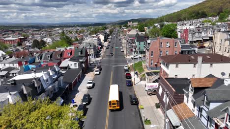 School-bus-driving-through-urban-USA-city