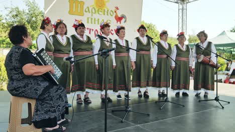 Bulgarische-Damenvolkschorgruppe-Tritt-Bei-Open-Air-Festival-Mit-Akkordeonmusiker-Auf