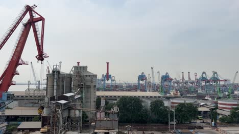 Aerial-View-Of-Tanjung-Priok-Port-With-High-Factory-Structure-And-Tower-Cranes-At-Industrial-Area