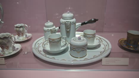 Elegante-Juego-De-Té-De-Porcelana-En-Exhibición-Con-Intrincados-Detalles-Dorados