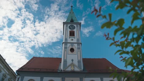 Church-tower-with-clock-against-a-bright-blue-sky-in-King-Tomislav-Square,-Varaždin,-Croatia