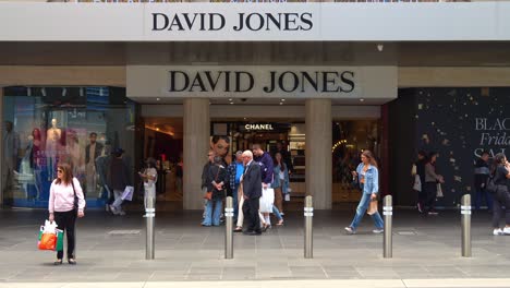 The-foot-traffic-of-the-David-Jones-flagship-store-in-bustling-downtown-Melbourne-city,-with-pedestrians-strolling-on-Bourke-Street-Mall-and-shoppers-shopping-in-the-store,-slow-motion-shot