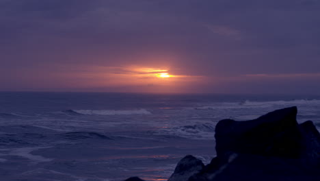 Bewölkter-Sonnenuntergang-An-Einem-Regnerischen-Tag-Mit-Blick-Vom-Strand-Und-Den-Felsen