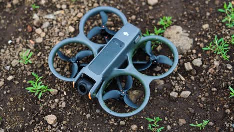 Compact-FPV-drone-on-brown-countryside-dirt-surface,-Czech-Republic