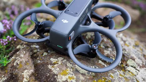 FPV-drone-with-built-in-propeller-guards-on-countryside-rock,-Czechia