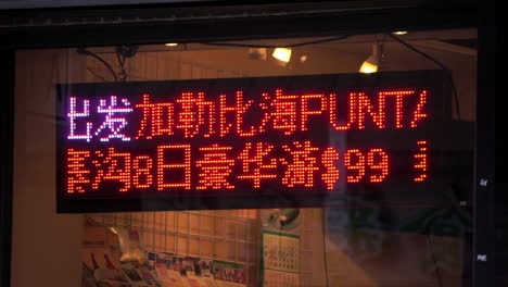 An-electronic-sign-scrolls-Chinese-Hanzi-characters-in-Chinatown-store-window