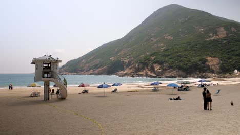 Families-enjoying-serene-beach-destination,-lifeguard-observation-tower