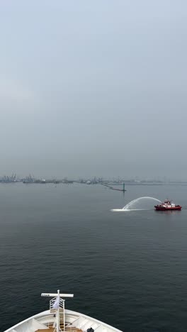 Vertical-Video-Of-Coast-Guard-Boats-Performs-A-Water-Salute-By-Spraying-Waters-In-The-Air