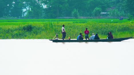 Un-Grupo-De-Aldeanos-Cruzando-Un-Río-Inundado-En-Una-Larga-Canoa.