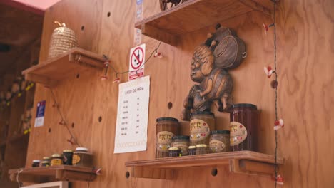 Shelves-with-honey-jars-and-wooden-carvings-at-a-market-of-traditional-crafts-in-Varaždin,-Croatia