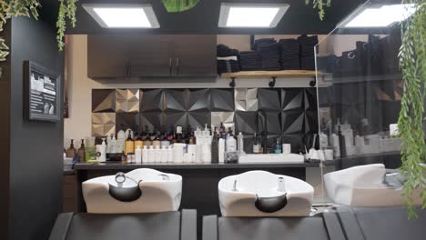 Interior-work-space-of-elegant-hair-salon-with-the-washbasins-and-table-with-products