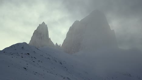 Snow-covered-peak-of-Mount-Fitz-Roy-shrouded-in-mist-on-a-winter-day