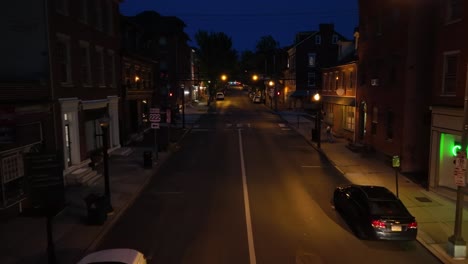 Person-walking-on-sidewalk-in-american-street-at-night