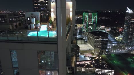 Moderna-Torre-Residencial-Con-Piscina-En-La-Azotea-Por-La-Noche-En-Atlanta,-Georgia.