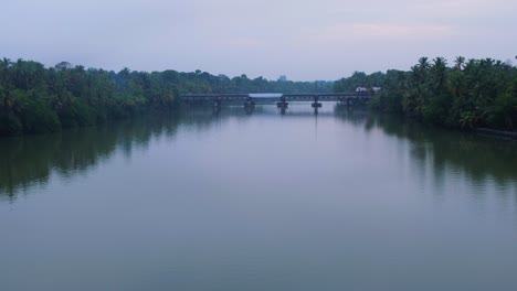 indian-train-passing-through-river-bridge-kuttanad-kerala,-Train-passing-through-forest-next-to-a-river