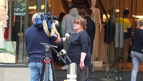 News-reporter-interviewing-local-people-on-Bourke-street-mall-in-downtown-Melbourne-city,-bustling's-Central-Business-District