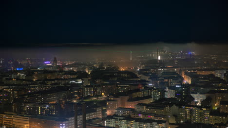 Time-lapse-of-foggy-night-in-the-Kallio-cityscape,-vibrant-lights-in-Helsinki