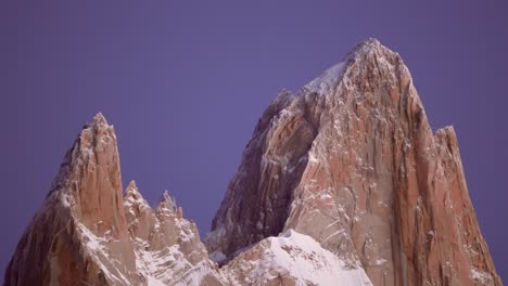 Majestuosos-Picos-De-Fitz-Roy-Y-Poincenot-Brillando-Al-Amanecer-Con-Un-Fondo-De-Cielo-Púrpura