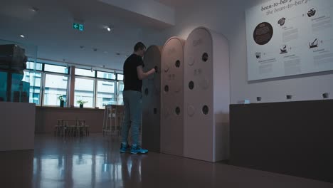 Visitor-interacts-with-display-at-Zagreb-Chocolate-Museum,-modern-interior-design