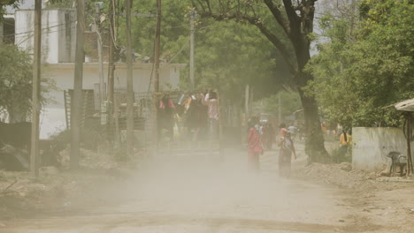 Vehicles-and-people-on-a-rural-dirt-road-in-India