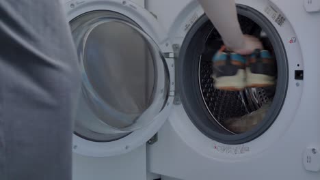 Woman-putting-dirty-shoes-in-the-washing-machine-London-United-Kingdom-June-2024