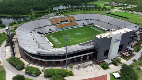 Toma-Aérea-Acercándose-Al-Estadio-Hipotecario-De-La-FBC-En-La-Universidad-De-Florida-Central-En-Orlando,-Florida