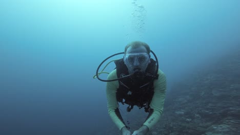 A-diver-takes-a-selfie-against-deep-blue-water