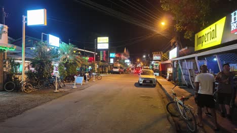 Fuera-De-Temporada,-Vibrante-Vista-Nocturna-De-La-Calle-Del-Centro-De-La-Ciudad-De-Puerto-Viejo-Con-Gente-Local-Caminando-Y-Bebiendo-Afuera-En-Costa-Rica