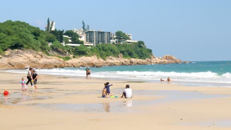 Sun-worshipers-enjoying-day-out-at-the-beach,-Asian-coastal-landmark