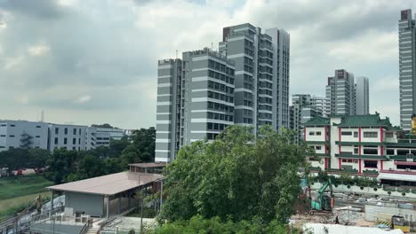 Vista-De-La-Ciudad-De-Singapur-Con-Cielo-Nublado-Y-Edificios-Desde-La-Ventana-Del-Tren-MRT