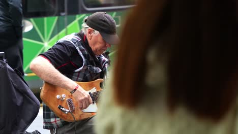 Alter-Musiker-Spielt-Auf-Der-Bourke-Street-Mall-Straßenmusik,-Spielt-Gitarre-Und-Singt-Im-Herzen-Der-Geschäftigen-Stadt-Melbourne,-Während-Fußgänger-In-Der-Szene-Vorbeigehen